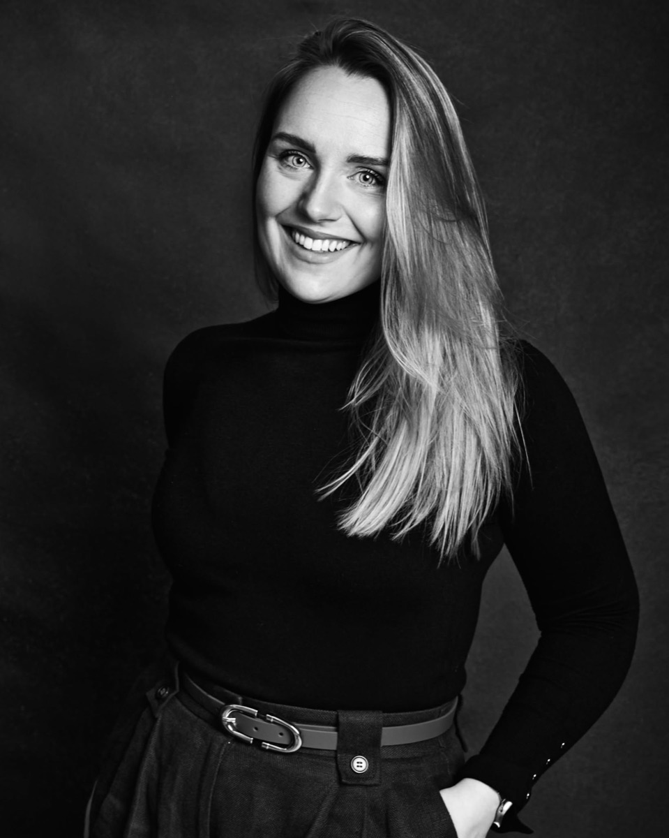 Marika Roseberg, portrait photographer, smiling in a black polo neck