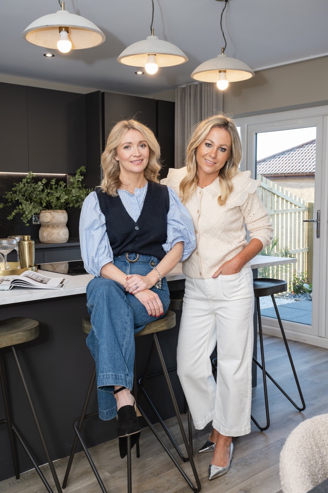 Caroline and Jane at a kitchen island under pendant lights