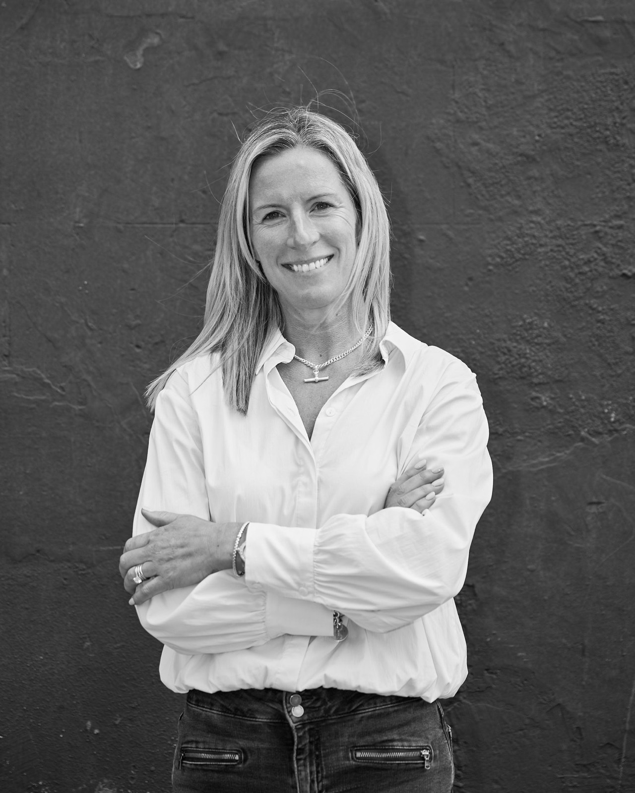 A black and white portrait of a woman with her arms folded