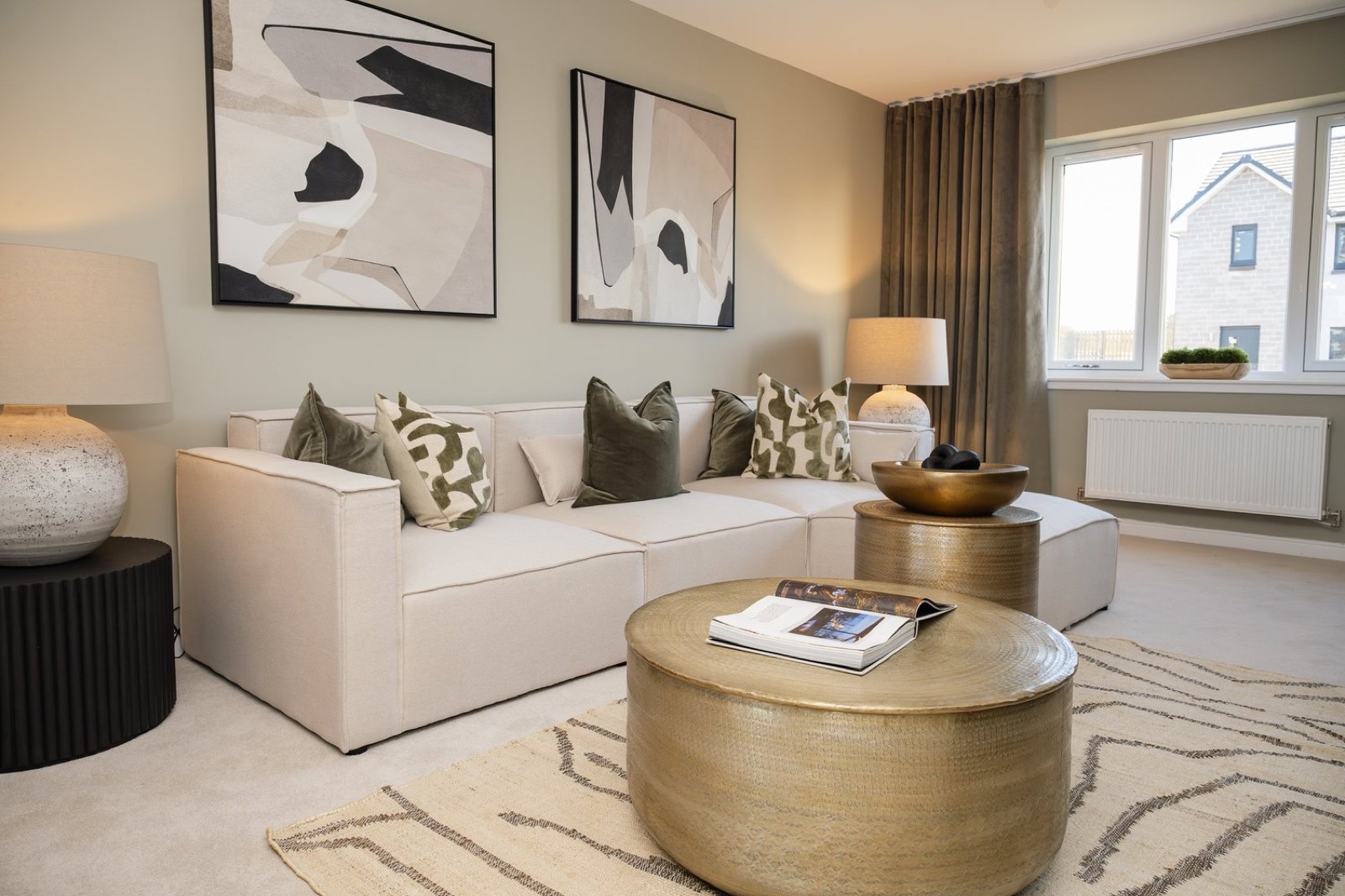 A cream living room with a round brass coffee table