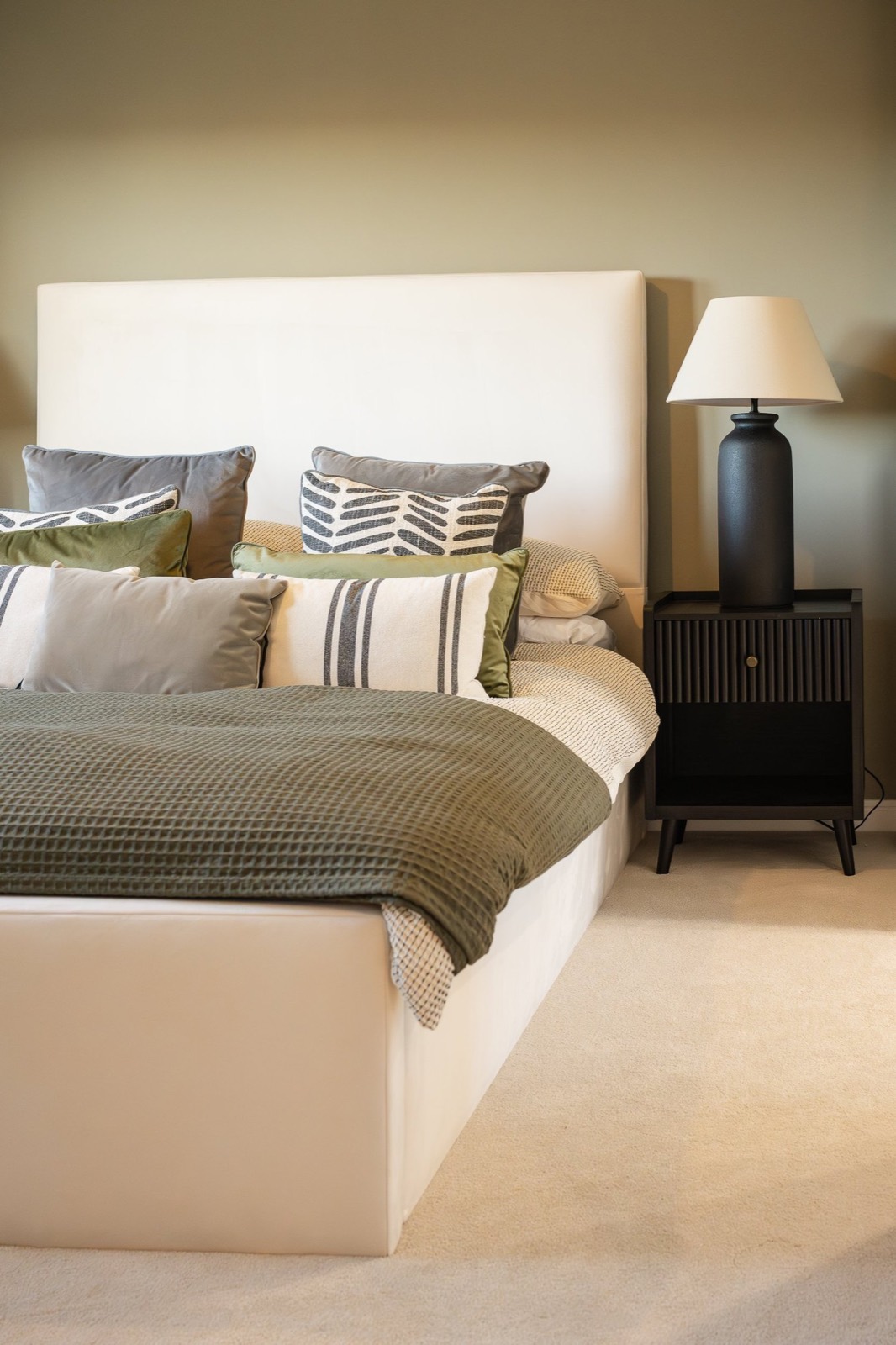 A neutral bedroom with a cream headboard