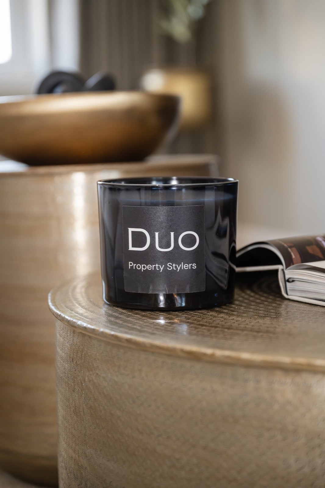 A Duo Property Stylers candle on a brass side table