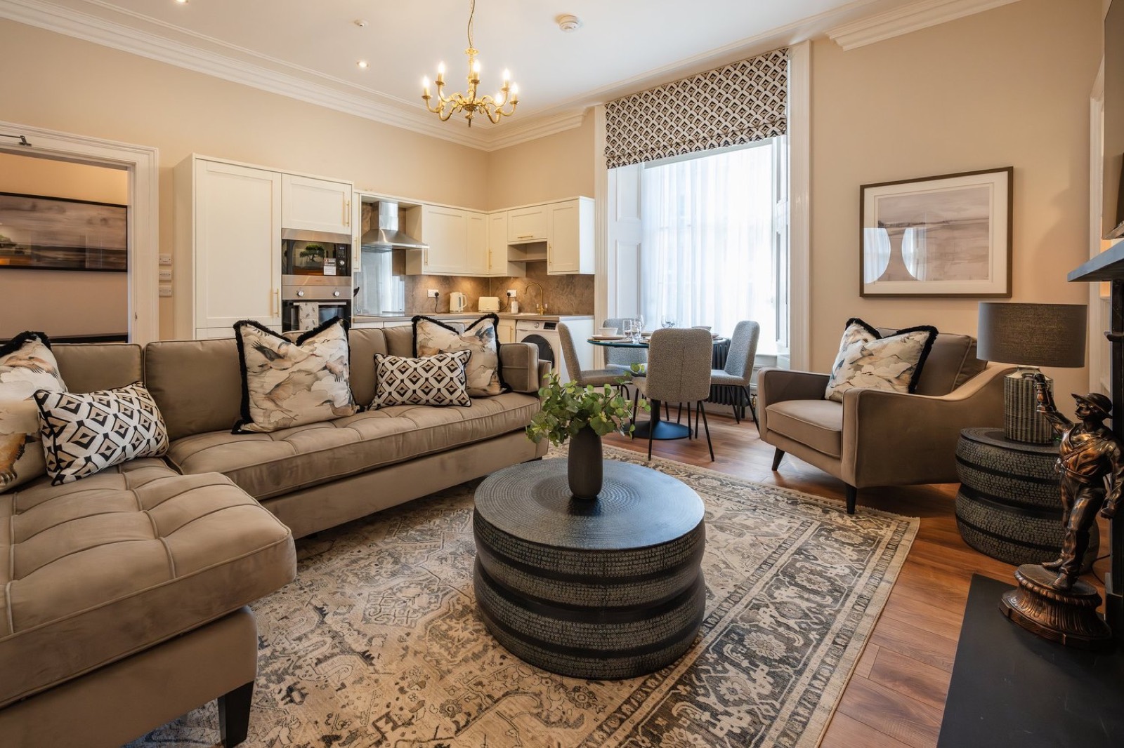 A warm period sitting room with a sectional sofa and chandelier