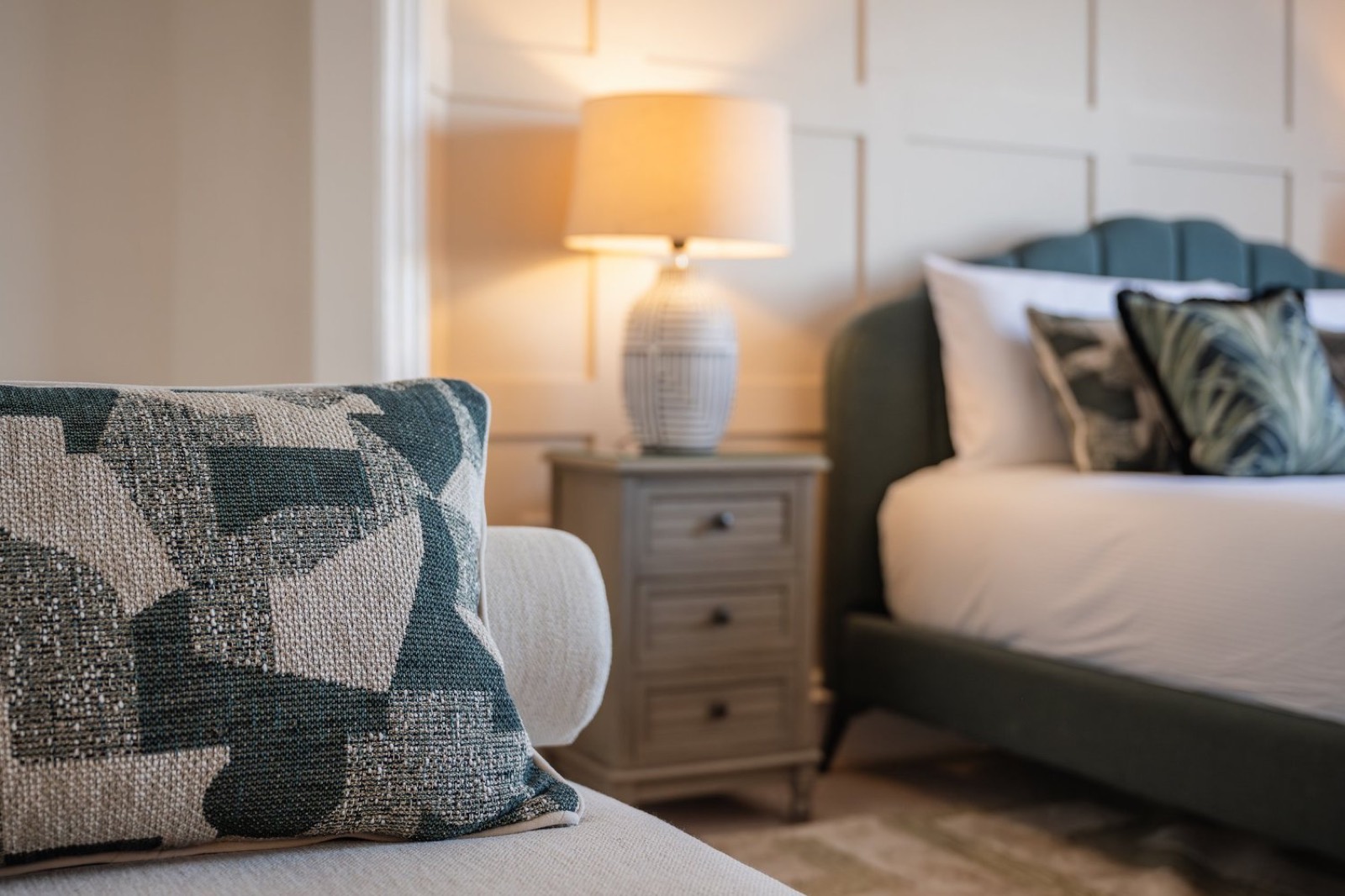 A panelled bedroom with a scalloped headboard