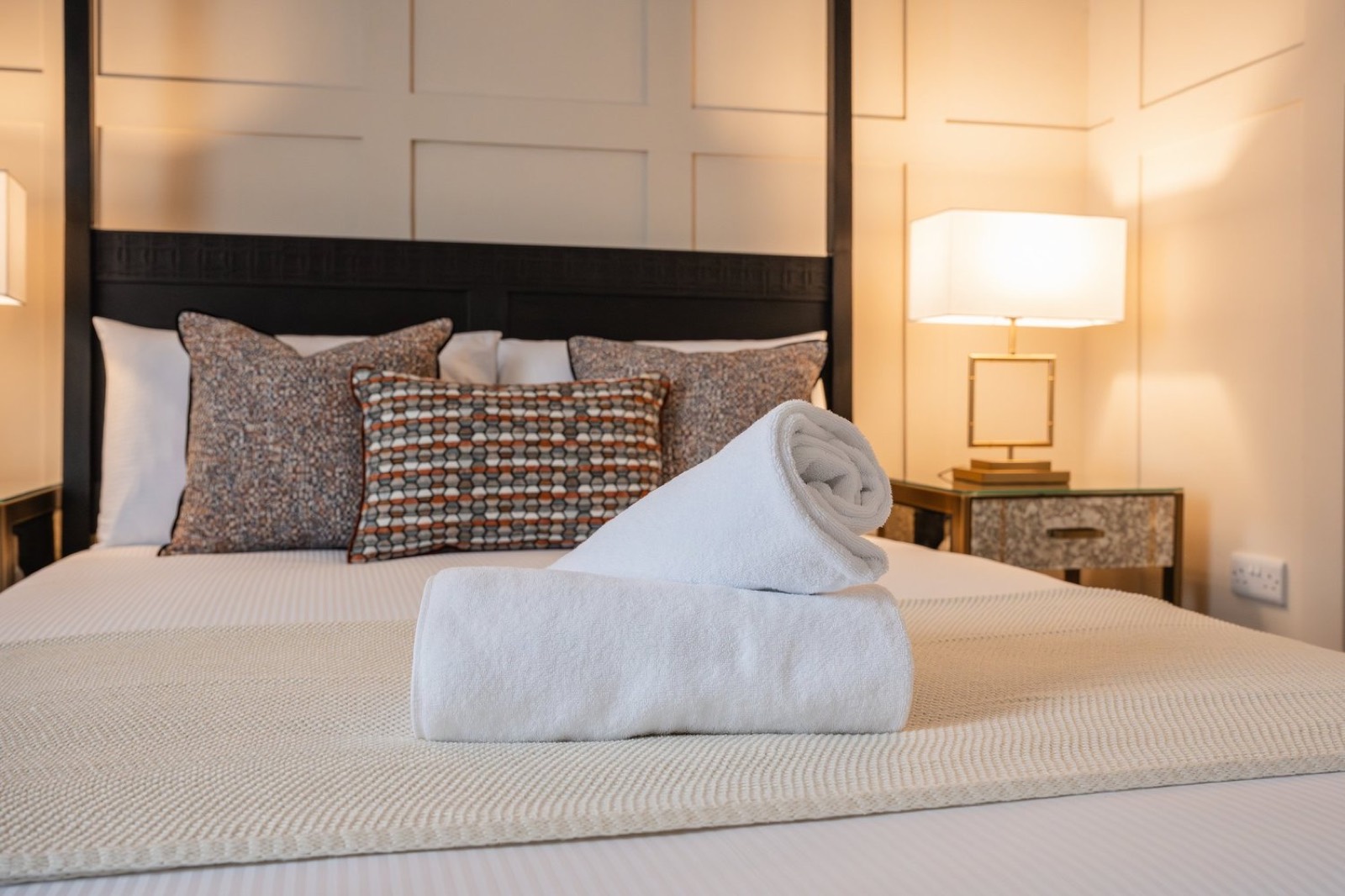 A four-poster bed with patterned cushions