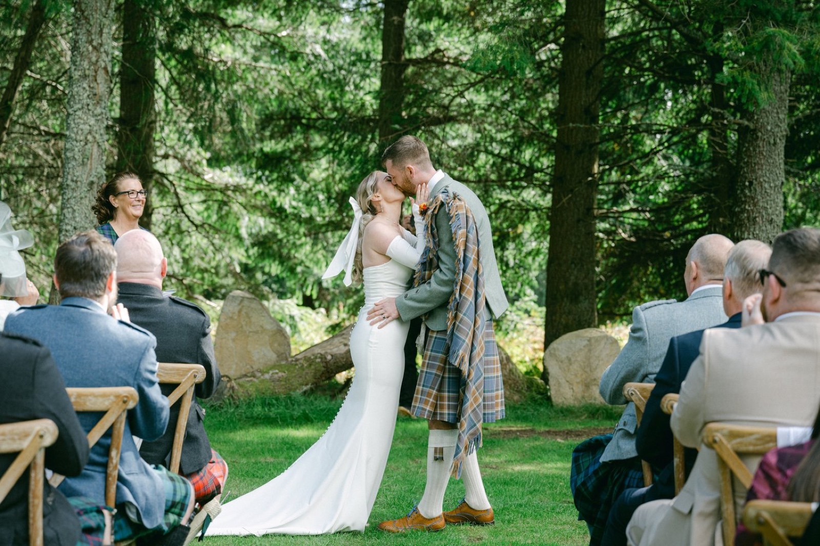 A first kiss at a woodland ceremony
