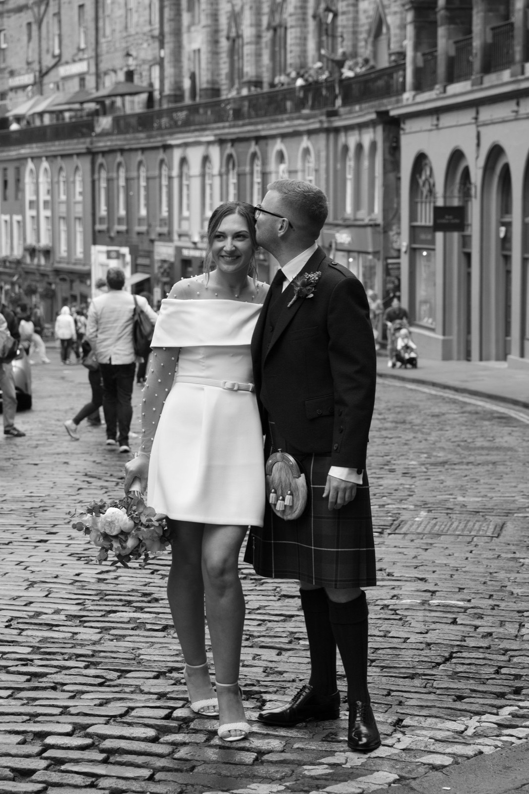 A black and white portrait of a couple on a cobbled Edinburgh street