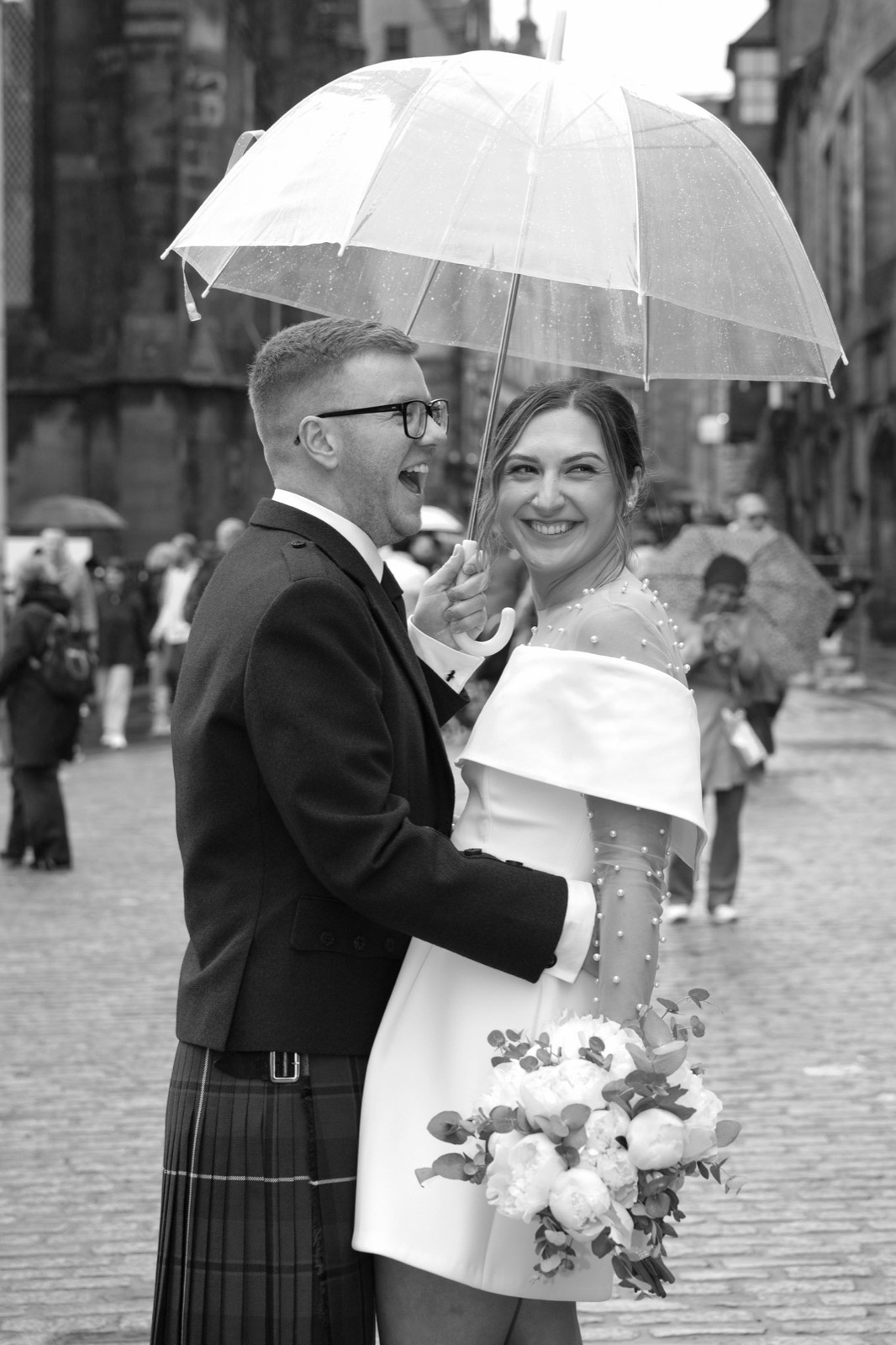 Kristina and Jordan laughing beneath an umbrella