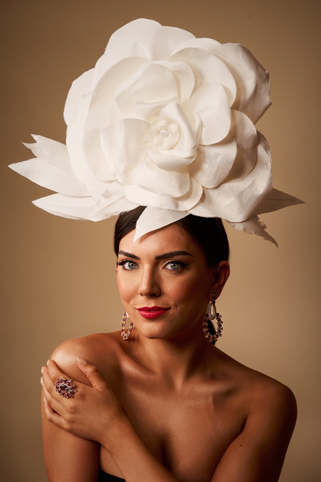 A woman wearing a large white flower headpiece