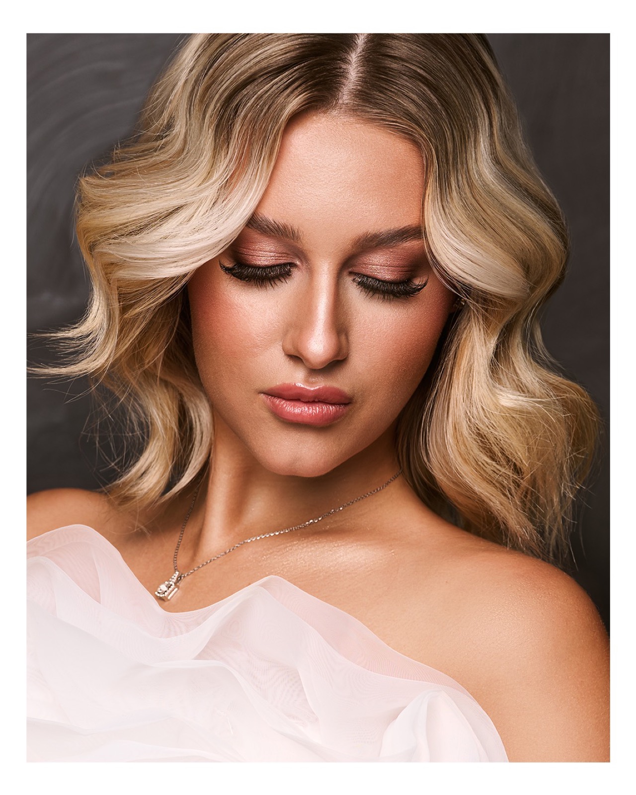 A close portrait of a woman with soft blonde waves